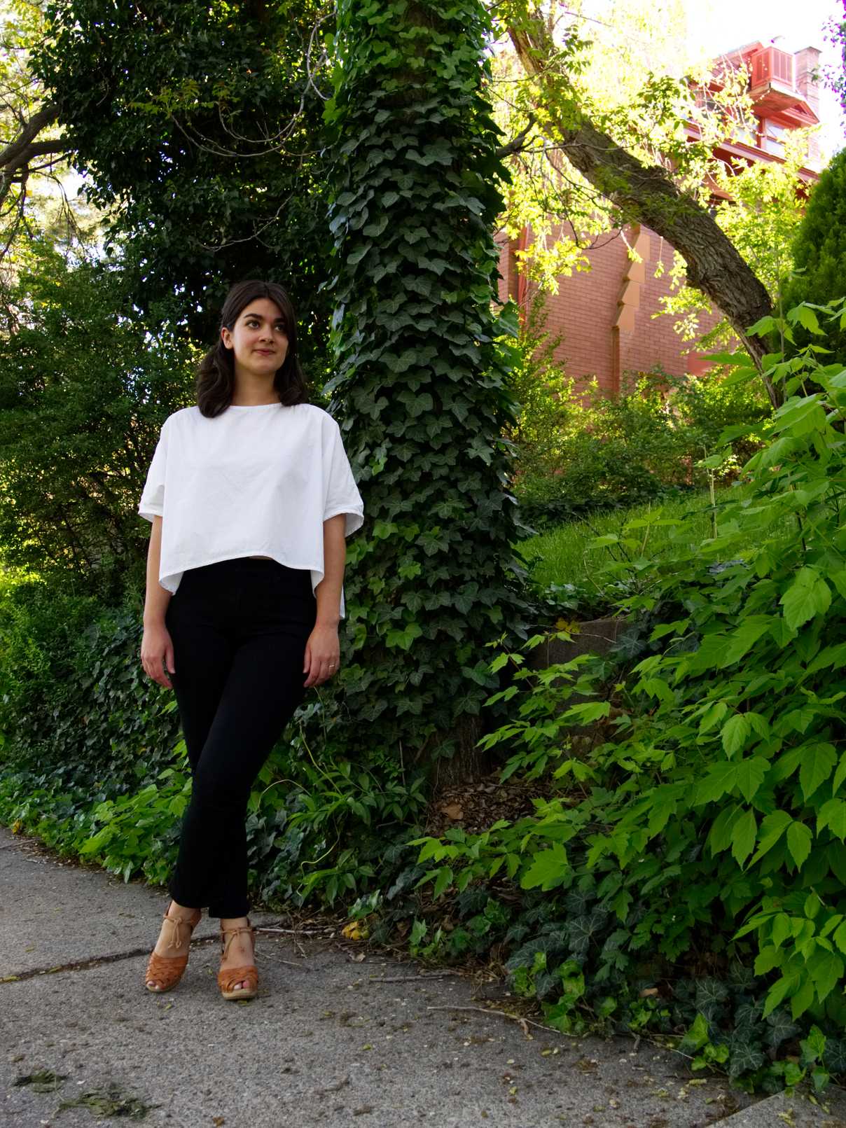 Sara wearing white cotton top and black high waist trousers with natural leather clogs
