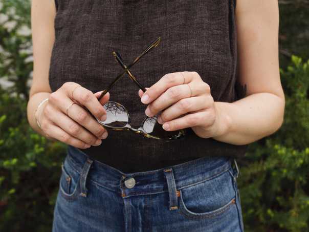 Details of Jacqs' accessories with sunglasses, rose gold rings, and a vintage Navajo bracelet