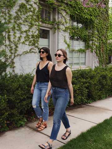 Sara and Jacqs walking in jeans, tanks, and sandals outfits